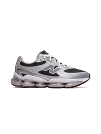 A New Balance sneaker in gray, black, and white, featuring the signature 'N' logo on the side, white laces, and a thick cushioned sole, shown against a plain white background.